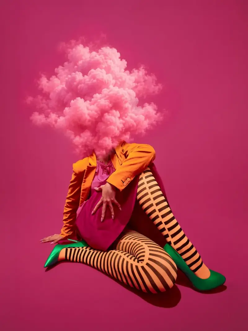 Pieza de la campaña Fantasía VISTO: modelo con chaqueta naranja y medias a rayas, con una nube rosada en lugar de la cabeza