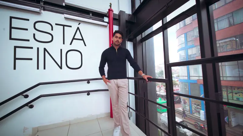 Modelo de la campaña «Está fino» en la escalera de VISTO, junto a la pared con «Está fino» y la ventana sobre San Victorino
