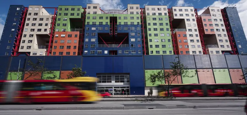Fachada del Centro Comercial VISTO sobre la Av. Caracas: la entrada principal, el edificio de colores y buses de TransMilenio pasando