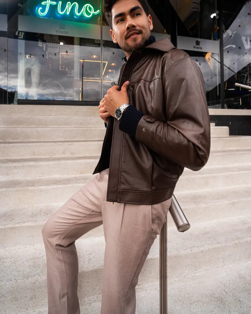 Modelo con chaqueta de cuero en las escaleras de VISTO, bajo el neón de la campaña