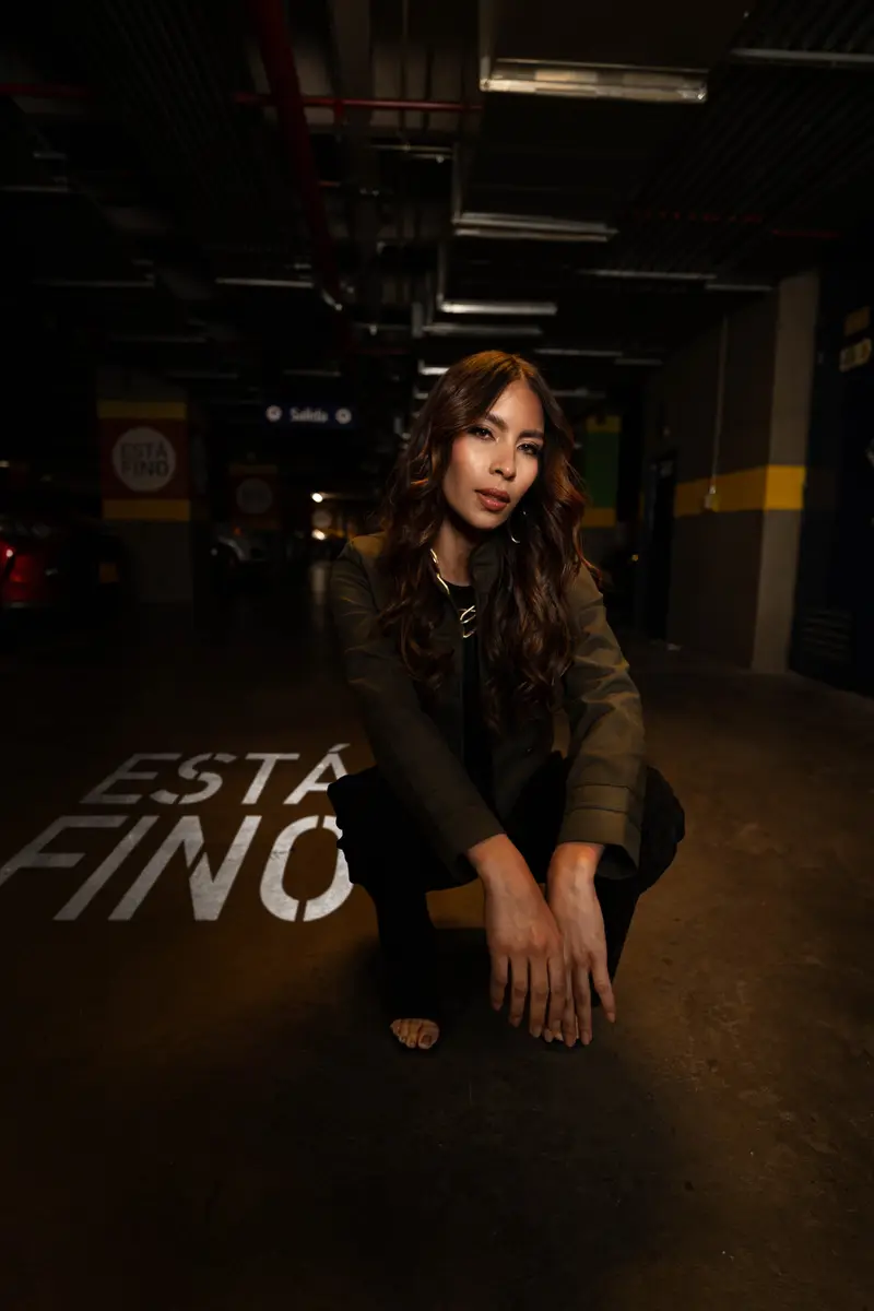 Modelo de la campaña «Está fino» en el parqueadero de VISTO, junto al letrero de la campaña pintado en el piso