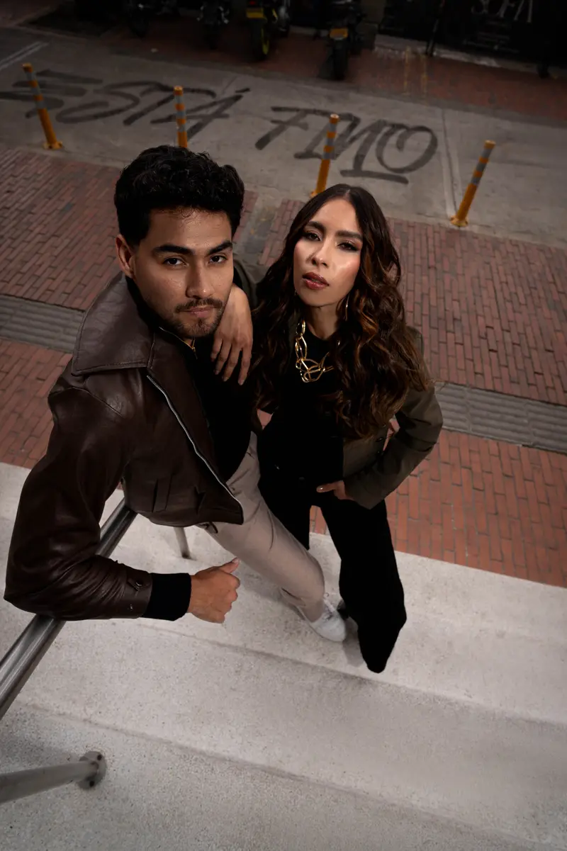 Pareja apoyada en la baranda de una escalera; abajo, «Está fino» escrito en el andén